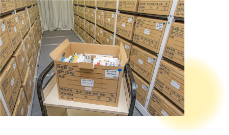 資料がぎっしり詰まった段ボールが並ぶ資料庫の写真