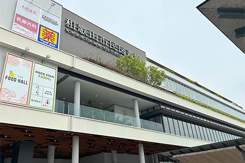 3階建てのモダンなビルの外観。一般のチェーン店の看板と和歌山市民図書館の文字が並んでいる