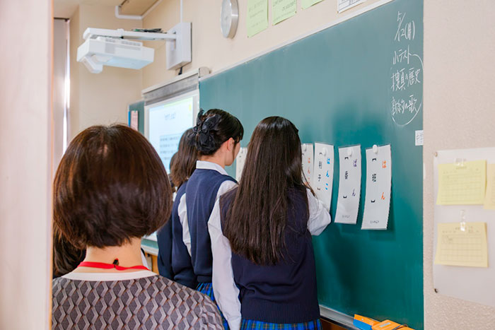 黒板に「藩」「番」「判子」などのことばが書かれた札が貼ってあり、それを辞書の見出し語順に並べていくみなさんの写真