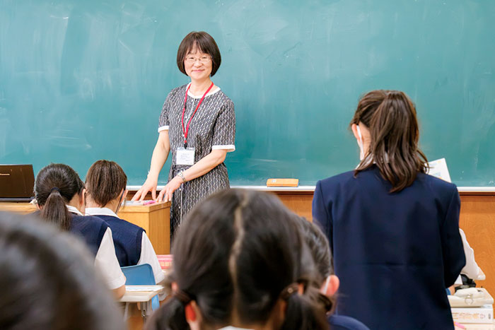 ひとりの生徒が発表している様子を見つめる柏野教授の写真