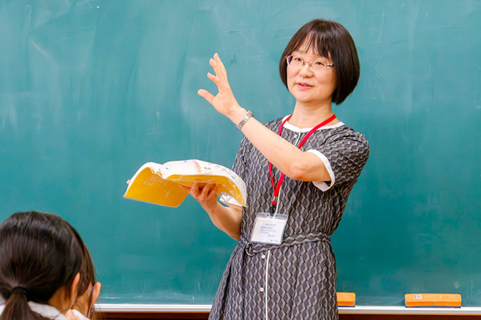 辞書を片手に説明する柏野教授の写真