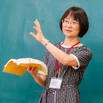 辞書を片手に説明する柏野教授の写真